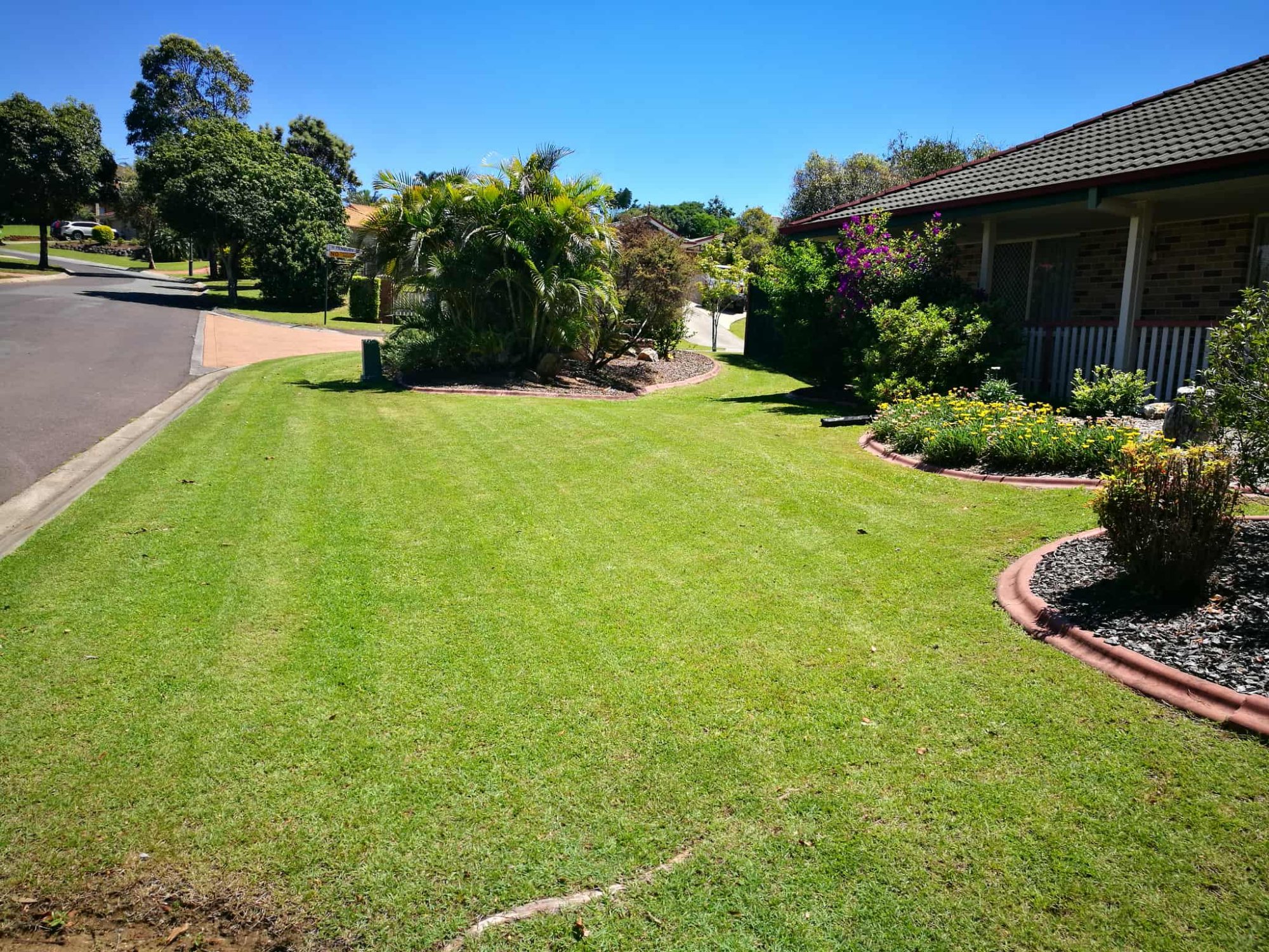 Beautifully mowed front yard with garden beds