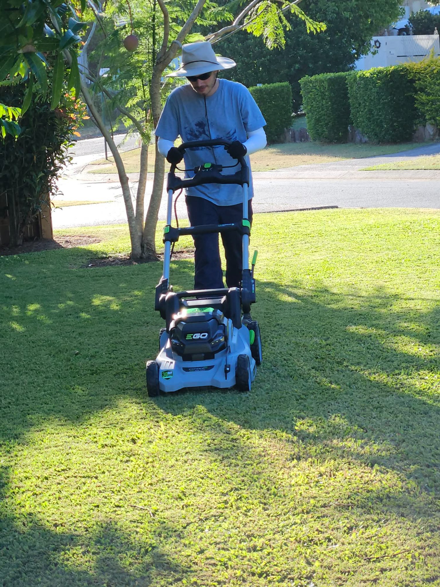 Logan mowing a lawn with an EGO electric mower