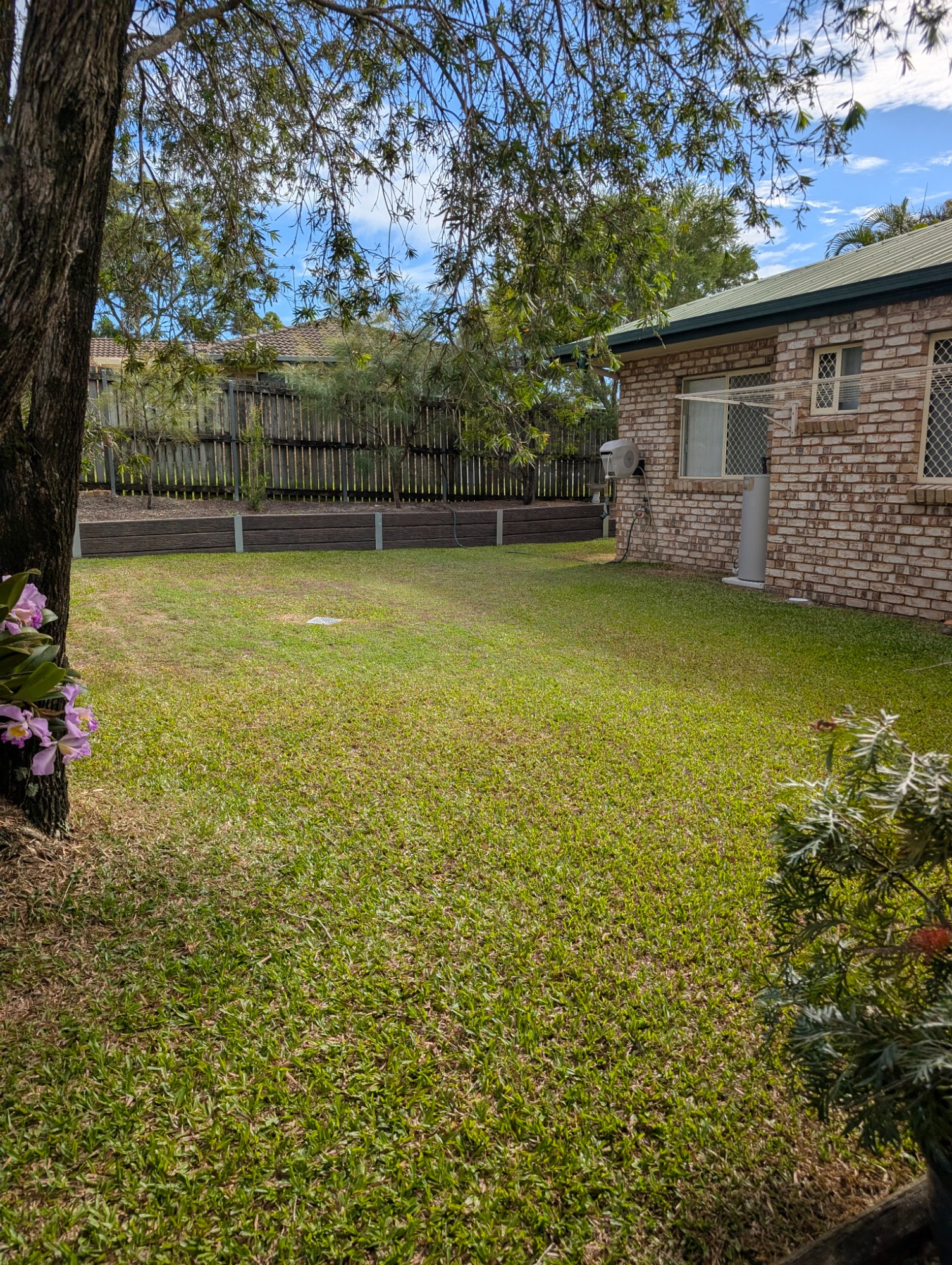 Neat backyard mow beside a brick house